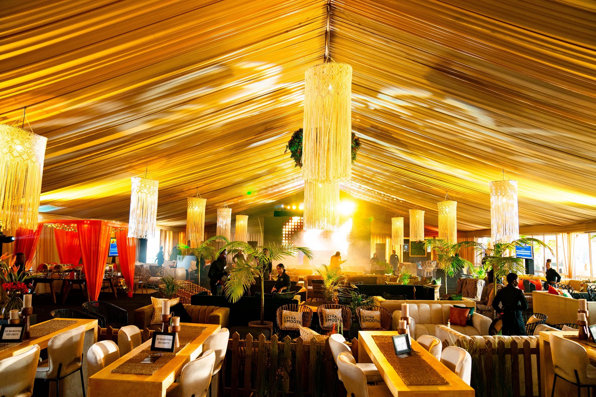 Ambrosia Haven marquee interior — golden chandeliers, luxury lounge seating, draped ceiling